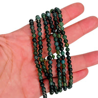 Moss Agate Bracelets draped over a hand to show off the vibrant color.