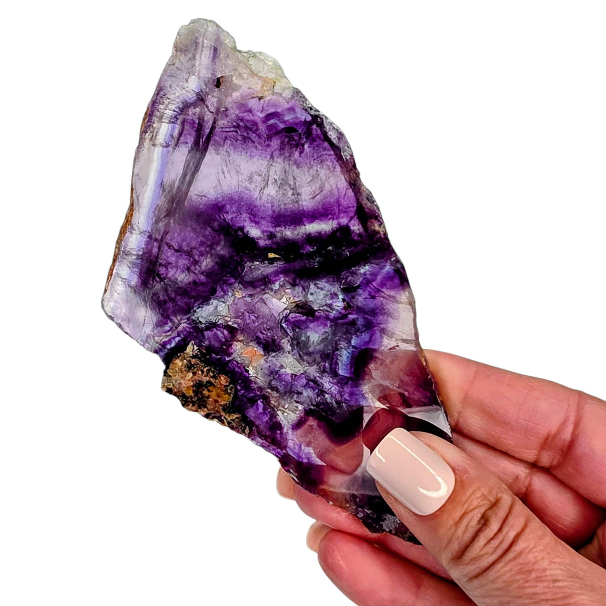 Rainbow fluorite slab with purple swirls and blue highlights, held in hand