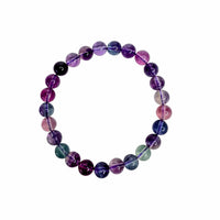 A beaded stretch bracelet made of polished round gemstone beads in shades of purple, pink, blue, and green, arranged in a circular shape on a plain white background.