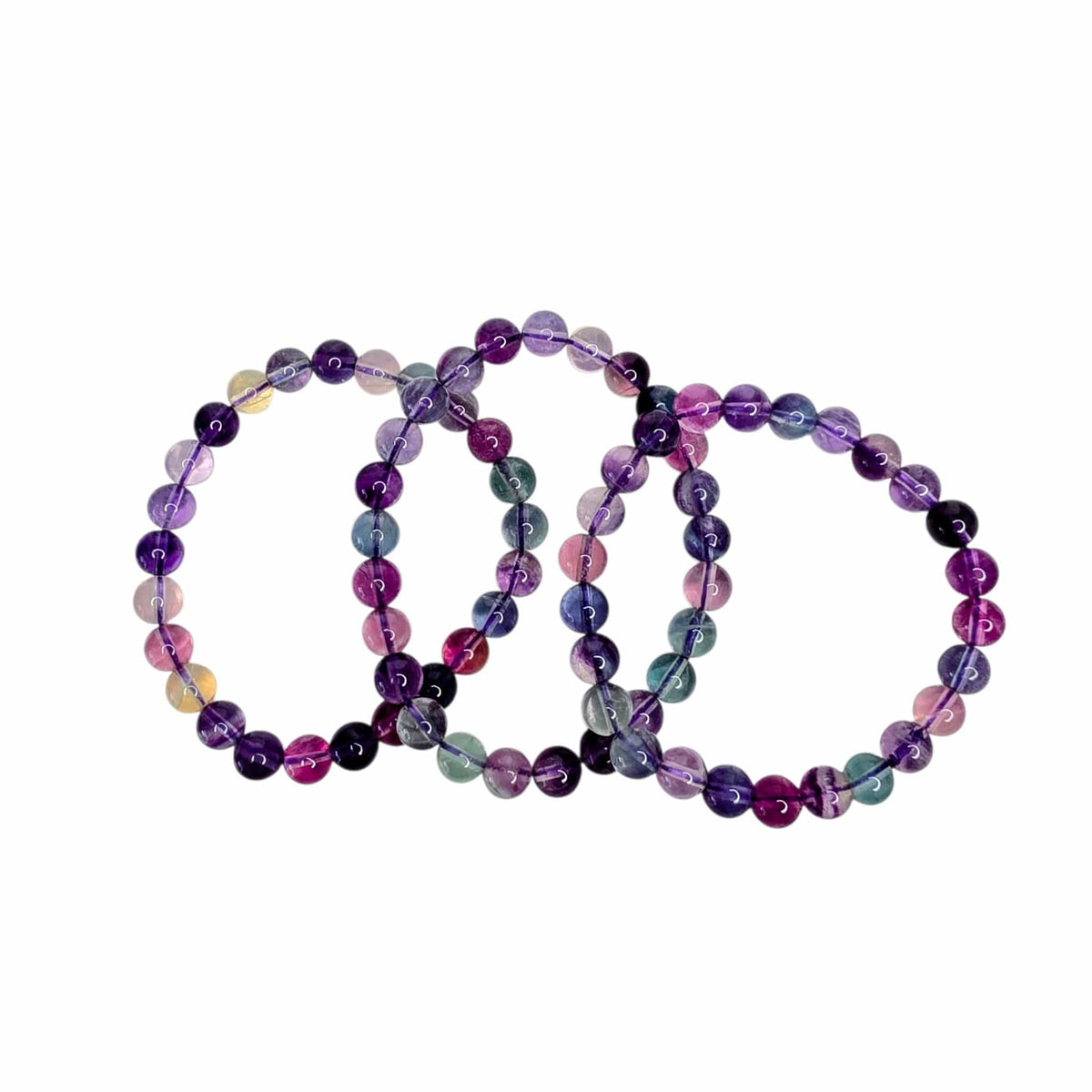 Three beaded stretch bracelets made of polished round gemstone beads in purple, pink, blue, green, and black, arranged overlapping on a plain white background.